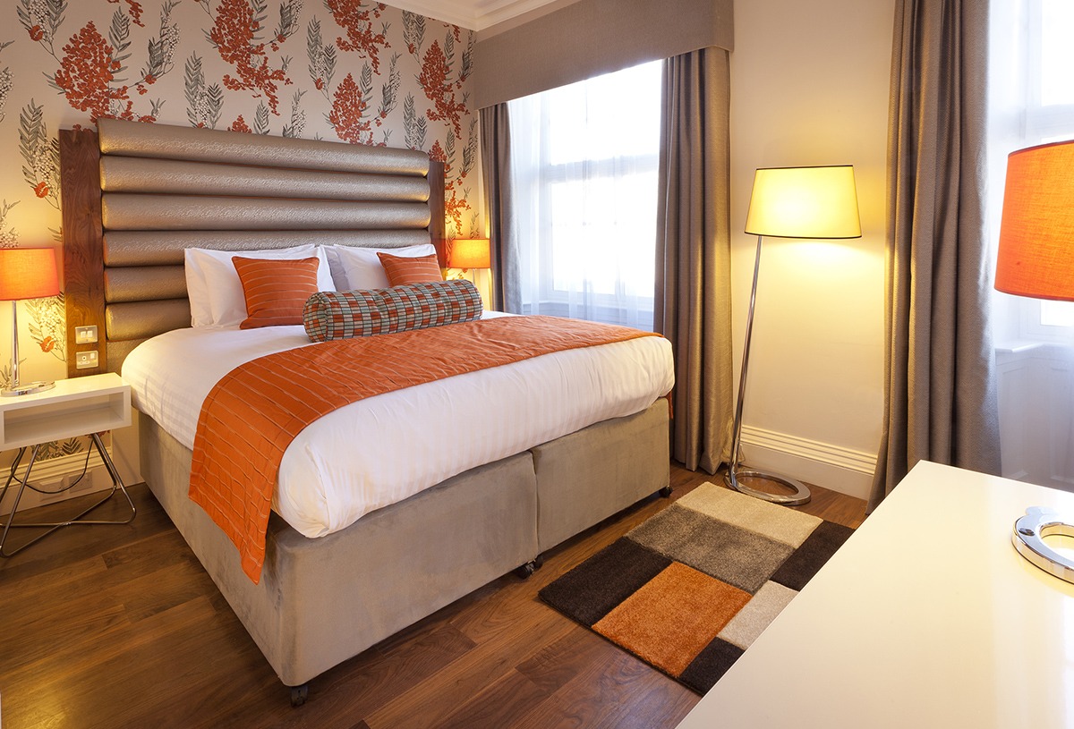 Double bed Standard Orange with floral wallpaper